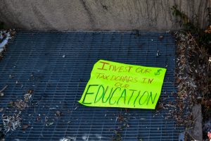 A demonstration sign outside the New Mexico State Capitol building.